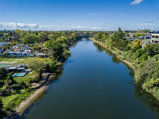 Fototapeta na wymiar Aerial drone view looking at Victoria Bridge over the Waikato River as it cuts through the city of Hamilton, in the Waikato region of New Zealand