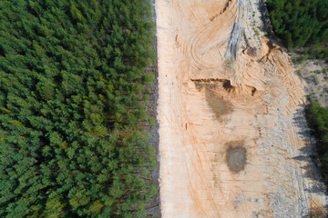 Above the border of a sand pit and forest on a sunny day (aerial photography). Kostroma region, Russia