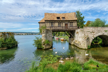 The Old mill (le vieux moulin) on the Vernon broken bridge on Seine river with swans in the foreground- Vernon, Normandy, France - obrazy, fototapety, plakaty