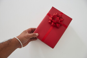 Man hands holding a red gift box on a white