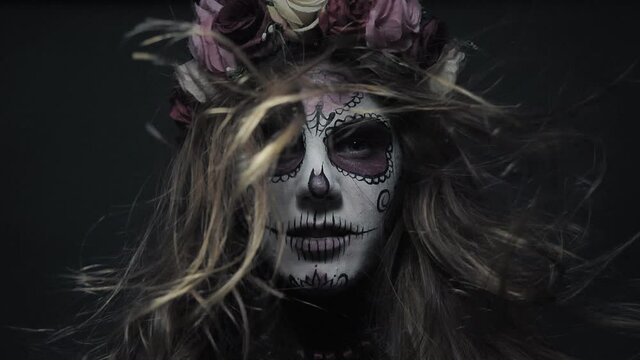 Halloween makeup, Santa Muerte or sugar mexican skull, makeup. The girl screams. Slow motion of hair in the wind