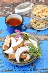 Putri Salju Kacang Mede or crescent-shaped cookies with cashew coated with powdered sugar. Popular Indonesian dessert to celebrate Eid al Fitr or Idul Fitri