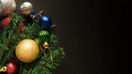 Christmas black background with decoration, red berry, bauble and fir tree branch