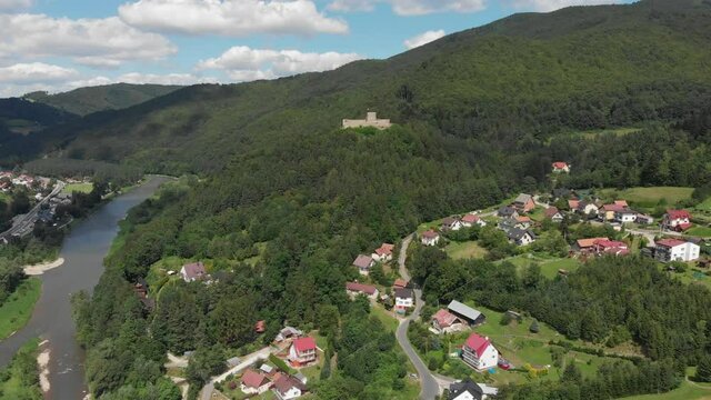 Village Sucha Struga and medieval castle in summer. Beskid Sadecki, Poland.