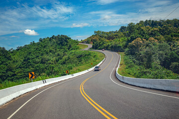 Rural Country Road on the Rush Green Forest Mountain range  under blue sky at Doi Phuka National Reserved Park, Nan Province, Thailand