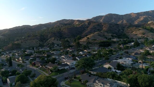 Flyover view of houses up against the hills in Southern California