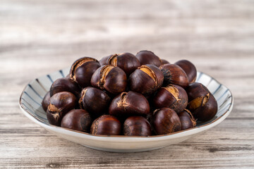 Close up of delicious roasted chestnuts with oil for eating.