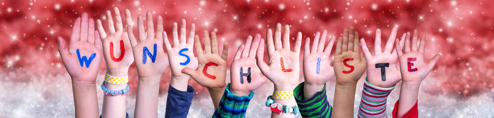 Children Hands Building Colorful German Word Wunschliste Means Wishlist. Red Snowy Christmas Winter Background With Snowflakes And Sparkling Lights