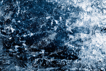 Ice texture background. Textured cold frosty surface of ice block on dark background.