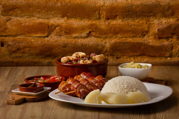 typical Brazilian barbecue, dish with chicken with bacon, rice, farofa, feijão tropeiro, beens, cassava
