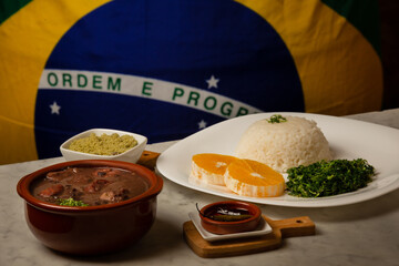 traditional Brazilian dish called feijoada, contains rice, beens, beef, pork, orange, vegetables
