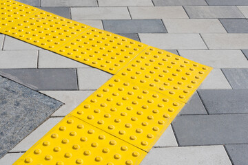 Yellow blocks of tactile paving for blind handicap. Braille blocks, tactile tiles for the visually...
