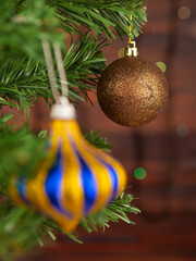 Striped Christmas ball with sparkles on the Christmas tree.Focus in the background. Portrait orientation of the photo.