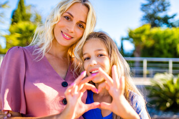 Smiling mother and beautiful daughter having fun on the beach