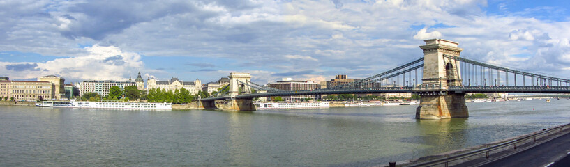 Obraz premium Panoramic of the Chain bridge that spans the River Danube in Budapest city, Hungary. Famous touristic landmark and attraction in the river.