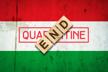 End of quarantine. The inscription on wooden blocks on the background of the flag of Hungary. The end of the pandemic. Business. Travels.