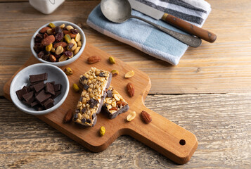Healthy snack, a bar made of cereals and nuts with honey and dark chocolate.