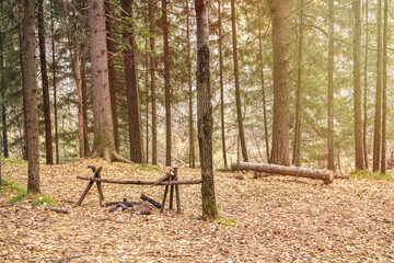 Camp site, fire pit next to stream woods with trees evening sunset