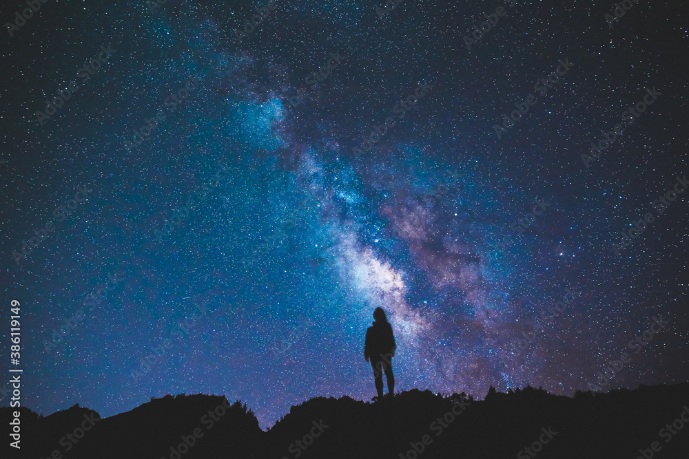 Wall mural silhouette of girl / woman standing on the hill. stargazing at oahu island, hawaii. starry night sky