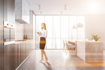 Fototapeta na wymiar Woman in white and dark wooden kitchen
