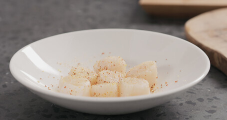 Seasoning raw scallops before cooking