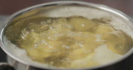 potato wedges boiling in saucepan
