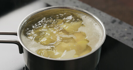 potato wedges boiling in saucepan