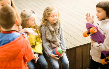 group of children sitting on wooden scaffolding schoolyard