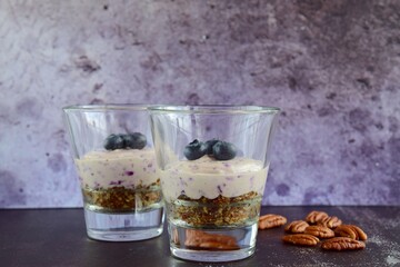 Vegan blueberry cheesecake with pecan date crust served in glasses