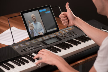 Fototapeta na wymiar Student showing a thumb up to his music teacher during a piano lesson