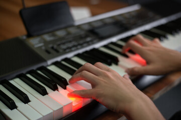 Fototapeta premium Man playing keyboard with lighting and looking at a display of a