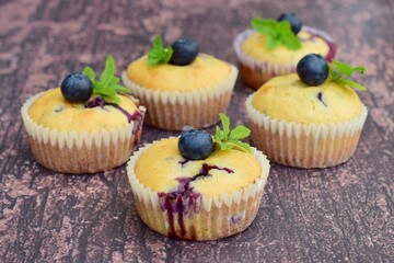 Blueberry coconut muffins garnish with mint leaves. Wooden background
