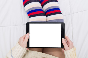 woman in long socks lying down using tablet or e-book