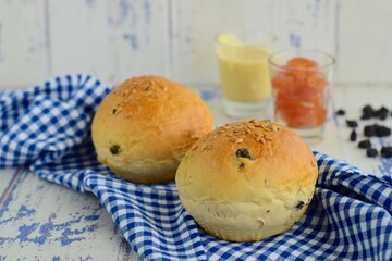 Homemade bread buns with berry and flax seeds. Served with jam and almond butter