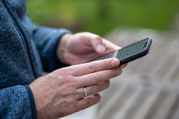 Mann bedient Smartphone draussen