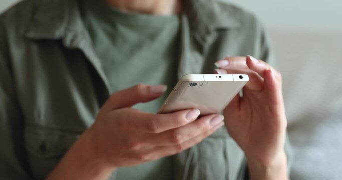Close up female hands holds smartphone choose goods, search information, buying on internet webstores, addicted girl waste free time in social media network chat. Wireless modern gadget usage concept