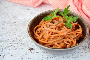 Fresh raw organic spiralized carrot noodle with tahini, parsley and sesame seeds
