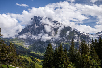 Fototapeta premium Beautiful summer day in the Valais Alps of Switzerland with low clouds over a mountain peak.
