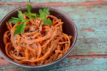 Fresh raw organic spiralized carrot noodle with tahini, parsley and sesame seeds