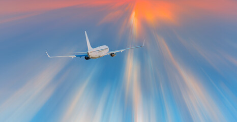 Fototapeta na wymiar Airplane in the sky with sun rays, amazing sunset in the background
