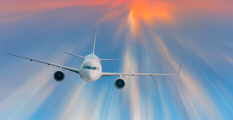 Airplane in the sky with sun rays, amazing sunset in the background