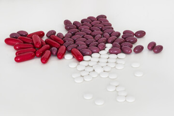 Closeup mix of pills, capsules and tablets isolated on a white table.