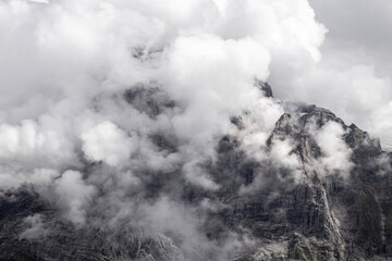 Fog swirling around a mountain in the Valais Alps of Switzerland on a summer day 