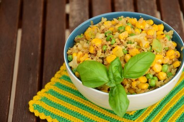 Cauliflower rice with corn and peas garnish with basil leaf