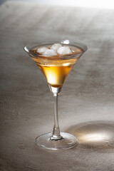 Alcoholic drink with ice on a light table, copy space