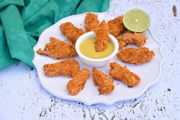 Gluten free chicken fingers breaded with coconut and spice served with mustard honey lime dip
