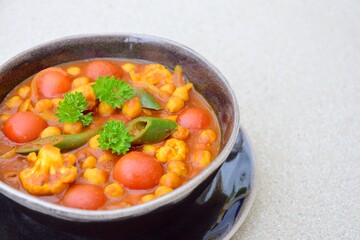 Spicy chickpea cauliflower tomato soup with green chili and parsley
