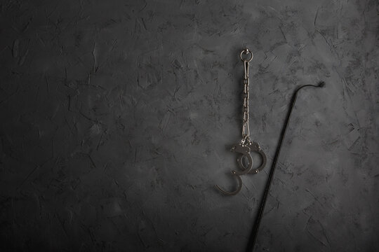 An einer Wand befestigte Handschellen mit Peitsche