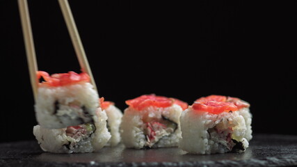 Lunch at a Japanese restaurant. Man eating sushi. Philadelphia sushi from fish, salmon, rice, cucumber. Sushi restaurant, sushi delivery. Selective focus