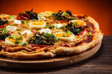 Pizza pepperoni with hard boiled eggs on wooden table
